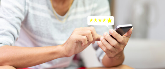 Customer pressing on smartphone with five star icon for feedback review satisfaction service