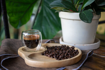 Espresso coffee cup and coffee beans on wooden plate