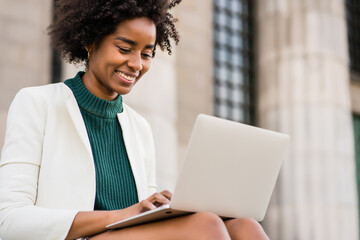 Business woman using her laptop outdoors.