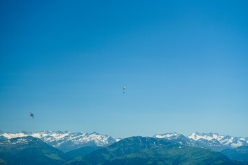 ein Gleitschirm Segler fliegt über den Alpen vor blauem Himmel und Bergpanorama