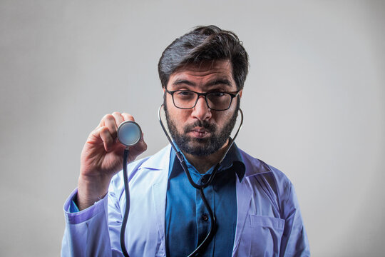 A Doctor Wearing Stethoscope And Medical Coat Looking Forward With Weird Expression