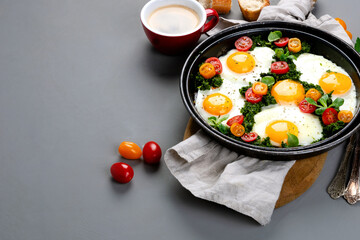 Fried eggs in frying pan for breakfast. Grey background
