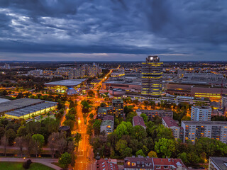 Obraz premium Wonderful twilight view over the illuminated Munich with business district and cars on a road from a high perspective.