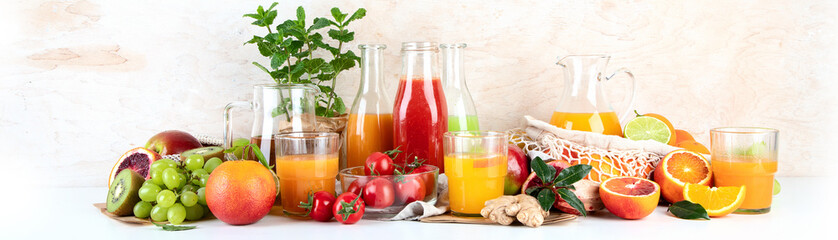 Healthy home made juices and fruits on light wooden background
