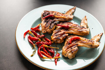 grilled chicken wings on a plate, restaurant serving, close-up top view