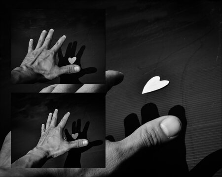 Hand try to hold a heart on black background