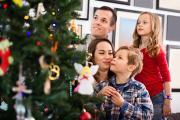 Happy family decorating Christmas tree at home