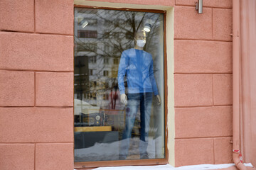 Obraz na płótnie Canvas Mannequin wearing a medical mask in the shop window. Coronavirus pandemic.