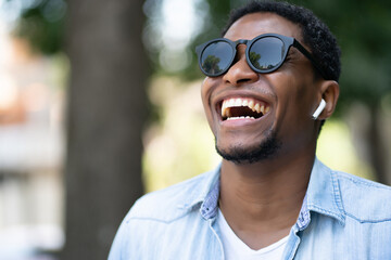 African american man smiling while walking outdoors.