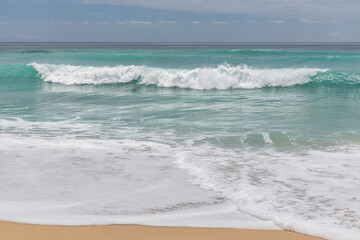 Fototapeta na wymiar Seascape background. Sandy beach, milky foam waves, blue ocean. Scenic waterscape. Horizon line. Nature and environment concept. Daylight. Copy space. Dreamland beach, Bali