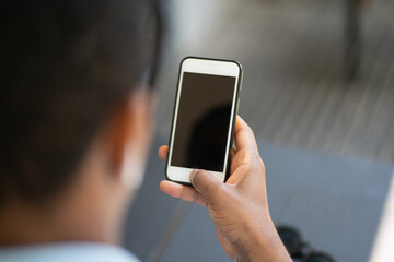 Man holding mobile phone with black screen.