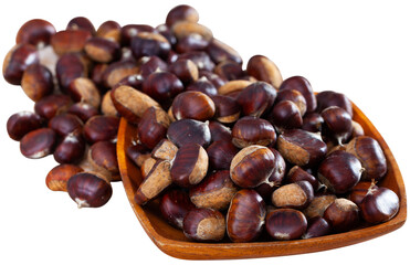 Pile of raw edible chestnuts in wooden bowl. Cooking of popular street food. Isolated over white background