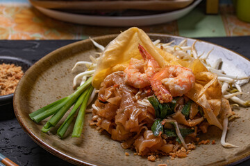 Pad Thai wrapped in egg on the black table Thai food