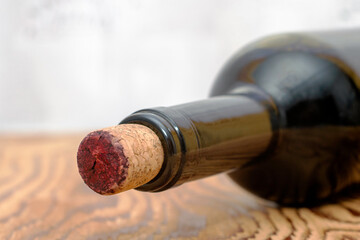 a cork sticking out of a wine bottle lying on a wooden table