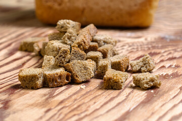rye crackers on a wooden table in the background in a blur a loaf of bread