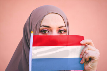 Muslim woman in hijab holds flag of Luxembourg