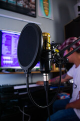 Microphone condenser with anti-pop filter in a preproduction studio at the background