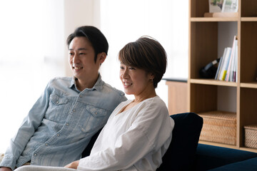 ソファに座りくつろぐ日本人ミドル女性