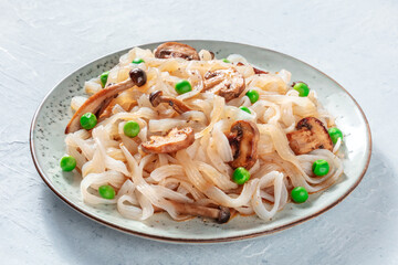 Konjac pasta with mushrooms and green peas, a healthy vegan low-calorie meal