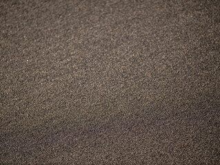 Black sand texture for background. Abstract sand pattern. Top view. Black sand beach in Bali. Copy space. Selected focus.