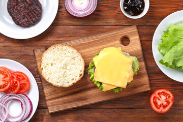 Homemade hamburger with cutlet, salad, onion, tomato and cheese. Cheeseburger, burger. Step by step. Top view. Cooking a burger
