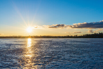 Beautiful winter landscape with frozen lake and sunrise sky. Composition of nature