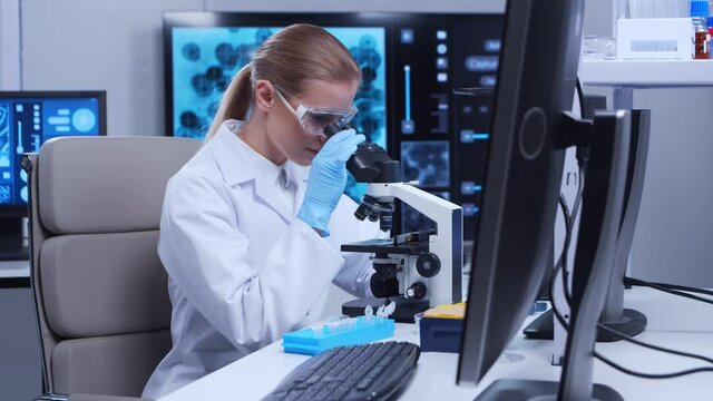 Professional female scientist is working on a vaccine in a modern scientific research laboratory. Genetic engineer workplace. Futuristic technology and science concept.