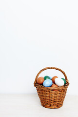 Easter eggs in a basket on a light background and church holiday