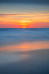 Obraz premium Sunset and beach. Seascape background. Bright sunlight. Sun at horizon line. Scenic view. Colorful sky. Sunlight reflection in water. Magnificent scenery. Copy space. Bali