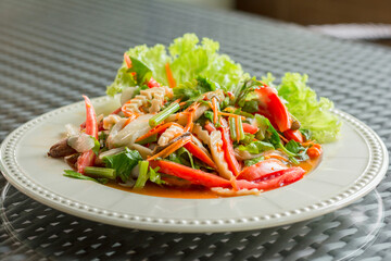 Vegan food concept. Thai hot and spicy mushroom salad with red tomato, sliced carrot, and green lettuce in a white plate.