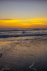 Yellow sunset on the beach. Seascape for background. Colorful sky. Beautiful water reflection. Sunlight on horizon line. Nature and environment concept. Copy space. Sunset in Bali.