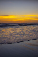 Yellow sunset on the beach. Seascape for background. Colorful sky. Beautiful water reflection. Sunlight on horizon line. Nature and environment concept. Copy space. Sunset in Bali.