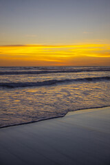 Yellow sunset on the beach. Seascape for background. Colorful sky. Beautiful water reflection. Sunlight on horizon line. Nature and environment concept. Copy space. Sunset in Bali.