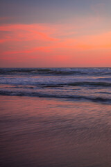 Fototapeta na wymiar Pink sunset on the beach. Seascape for background. Colorful sky. Beautiful water reflection. Sunlight on horizon line. Nature and environment concept. Copy space. Sunset in Bali.