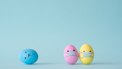 Covid-19 danger. Vaccine risk. Conceptual composition. Colorful painted Easter egg couple with face in protective mask design ignoring death isolated on blue empty space background.