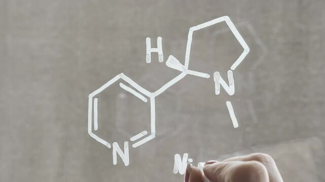 Drawing of the chemical structure of nicotine on the glass with a white marker.