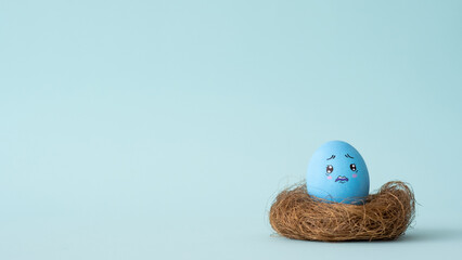 Mortgage risk. Loan scam. Real estate tax. Blue painted egg with scared desperate face pattern...