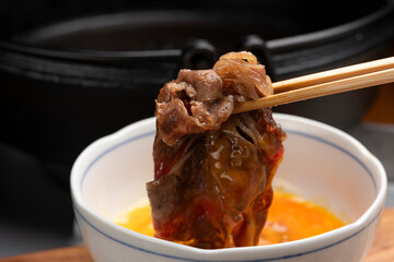 すき焼きの肉に溶き卵をつけて食べる