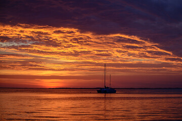 Fototapeta na wymiar Summer traveling yachting. Boat on water at sunset. Sailboats on ocean sea water.