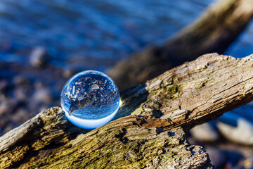 Glass ball stands at sea in the sand of Jurmala