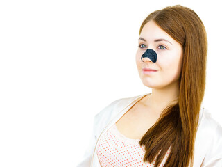 Woman applying pore strips on nose