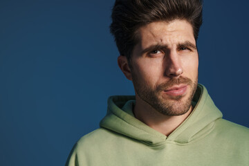 Perplexed handsome man in sportswear posing and looking at camera