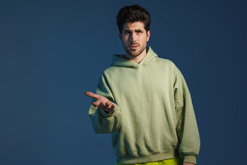 Perplexed handsome man in sportswear posing and gesturing at camera