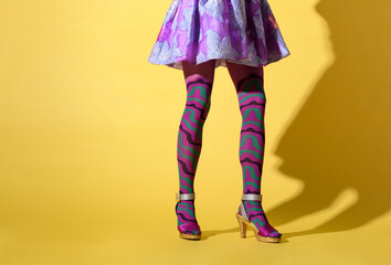 Woman with flared skirt and skinny legs wearing a purple collant