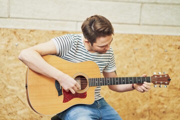 Handsome man playing guitar in studio
