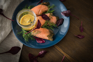 Gravlax Graved Lachs mit Rote Beete Blätter Salat, Dill, Rævesovs Senf Soße auf dunkel blau...