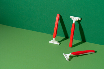 Disposable razor on green background, studio shot