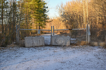 gravel road with big gate and other obstructions