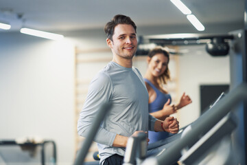 Fototapeta na wymiar Two people working out on treadmill