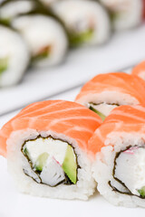 Maki Sushi - Roll made of smoked salmon and cream cheese. Traditional Japanese cuisine concept, over white background.